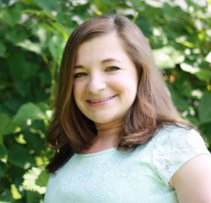 Image description: photograph of white woman with long brown hair. She is smiling and looking at the camera .