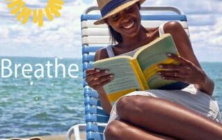woman reading a book in lounge chair with ocean in background