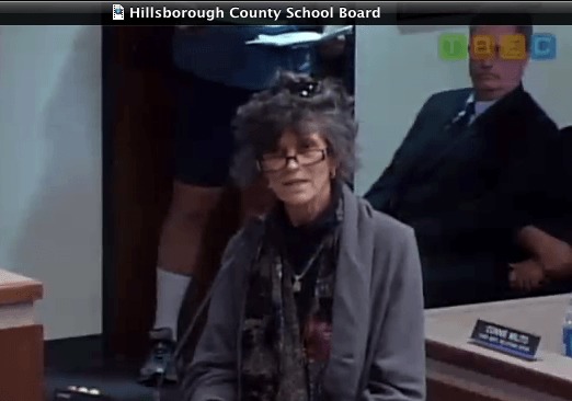 woman with black and gray hair speaking at podium