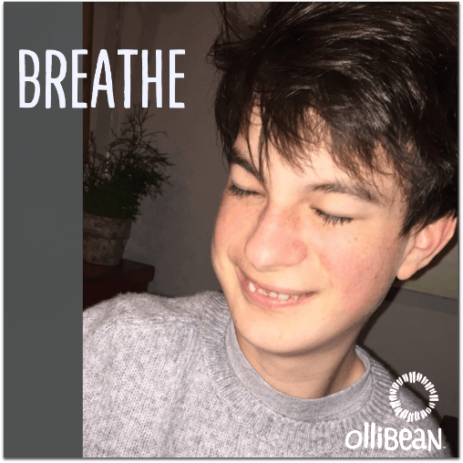 Image description: Photograph of boy with white skin and brown hair smiling with his eyes closed. "Breathe" is in text at top of image and Ollibean Logo is at the bottom.