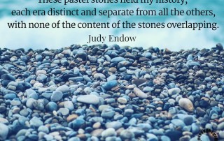 Photograph of stones on a beach. Text reads " hese pastel stones held my history, each era distinct and separate from all the others, with none of the content of the stones overlapping. Judy Endow on Ollibean.